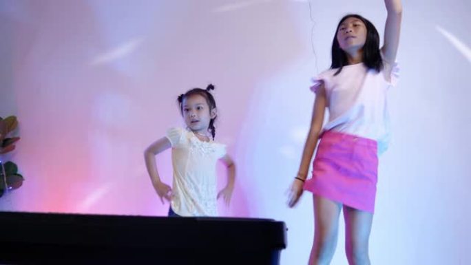 快乐的亚洲儿童在家庭派对上一起跳舞，在家用led灯，生活方式理念。