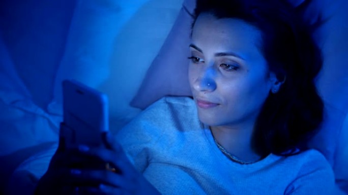 在床上使用智能手机的女人