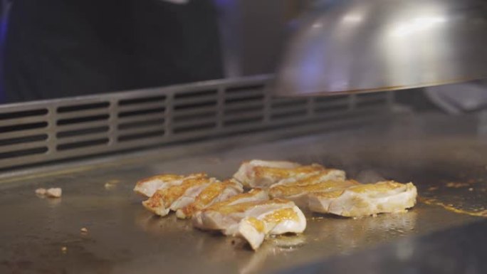 日本厨师制作铁板烧的场景。铁板烧是一种使用扁铁锅烹调的日本料理。蔬菜，调味料，在日本餐厅的平底锅上一