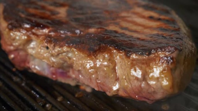 在网格上烧烤牛肉牛排，在烤架上烹饪多汁的肉牛排