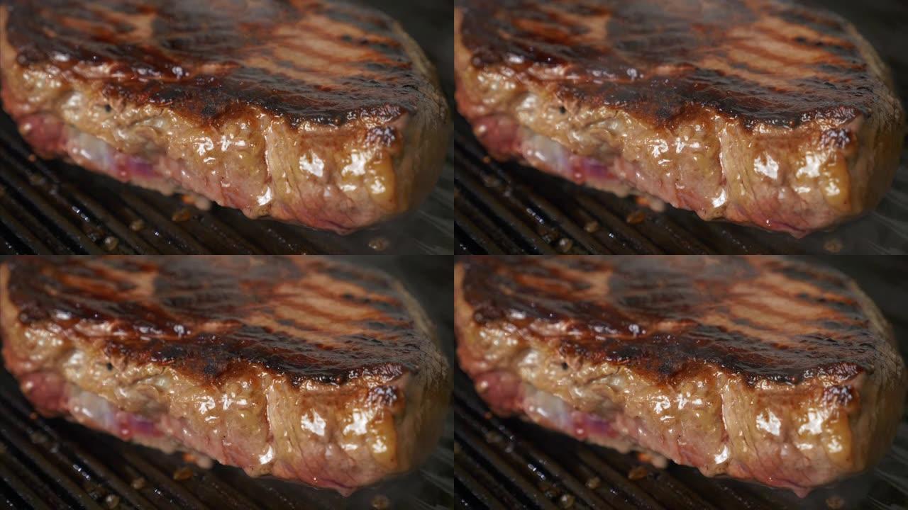 在网格上烧烤牛肉牛排，在烤架上烹饪多汁的肉牛排