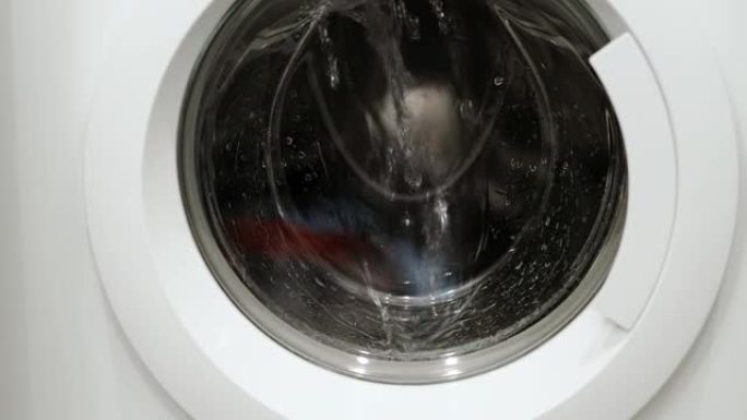 洗衣机中衣物旋转的特写视图隔离。家电概念。