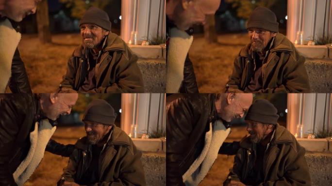 路人晚上在人行道上和无家可归的人说话。