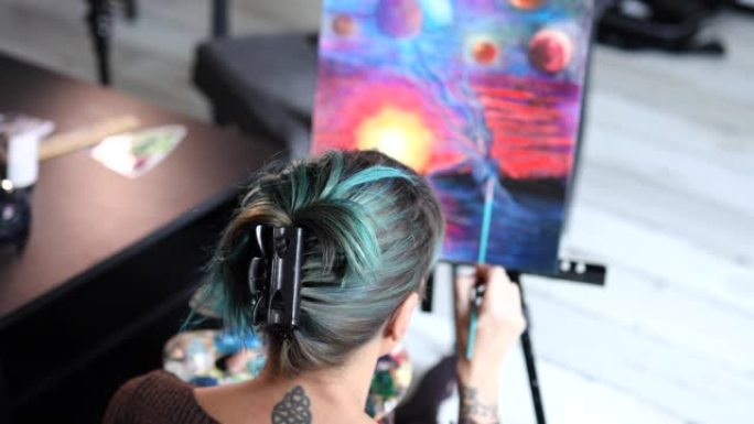 城市女艺术家在她的艺术工作室里用油画在画布上绘画