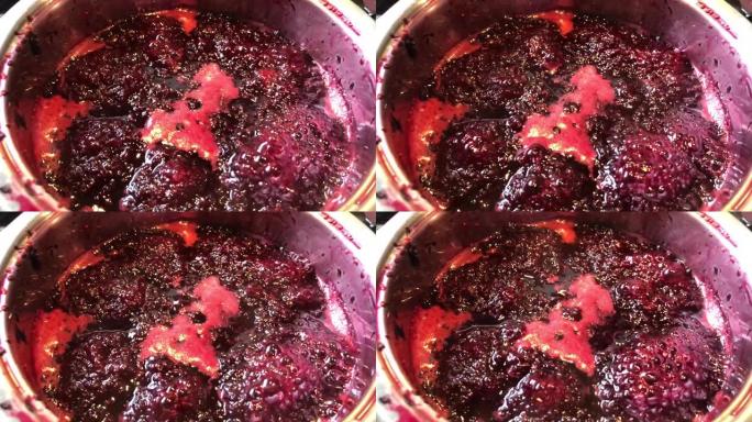 在平底锅里煮黑莓做果酱。