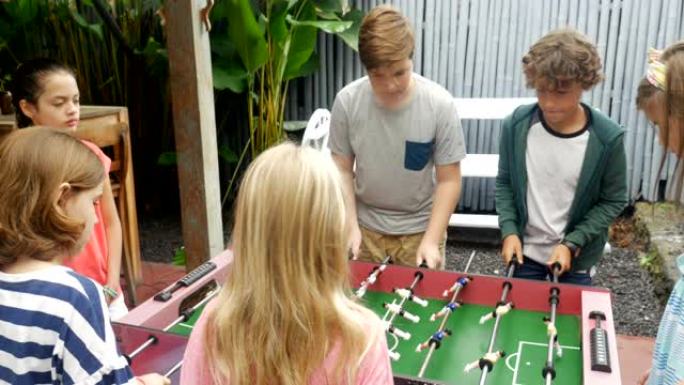 年轻女孩对年轻男孩玩桌上足球，女孩得分获胜
