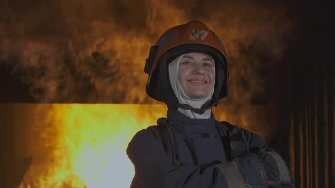 SLO MO消防员，消防战士带着火走向摄像机，在背景中肆虐。