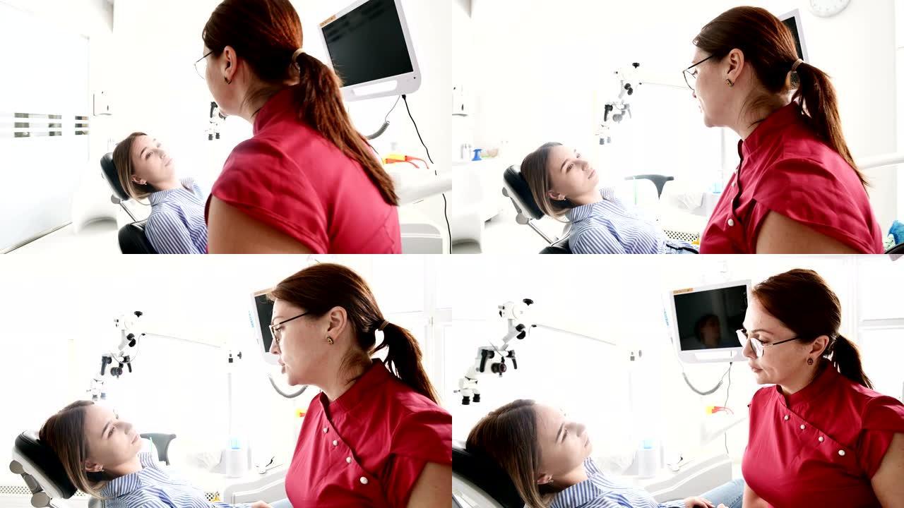 一名年轻女孩正在与一名戴着眼镜的牙医妇女进行咨询，正坐在一间诊所的椅子上。医生和病人的谈话