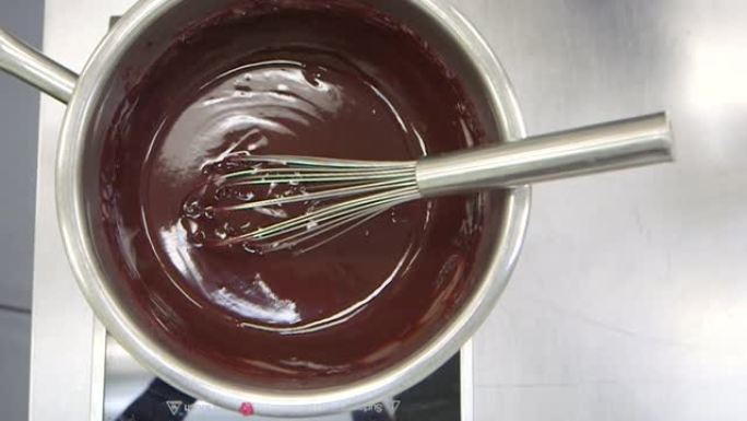 Chocolatier的厨房-薄荷叶和干芙蓉叶在奶油中炖，通过漏勺过筛，倒入并搅拌到巧克力中，制成甘