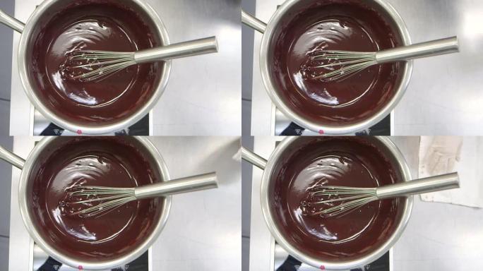 Chocolatier的厨房-薄荷叶和干芙蓉叶在奶油中炖，通过漏勺过筛，倒入并搅拌到巧克力中，制成甘