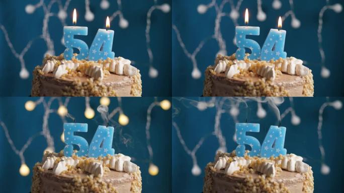 蓝色背景上有54号蜡烛的生日蛋糕。蜡烛吹灭了。慢动作和特写视图