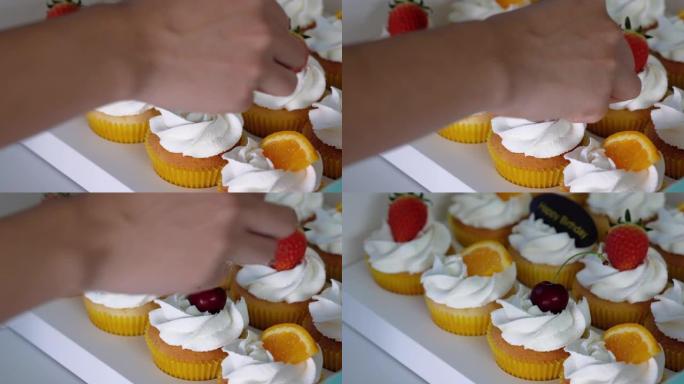 糕点厨师用樱桃装饰纸杯蛋糕