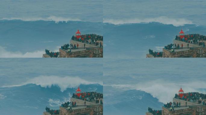 一大浪涌向葡萄牙纳扎尔悬崖上的红色灯塔的惊人镜头。