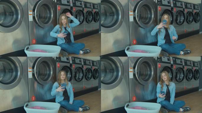 等待洗衣服的年轻女子坐在地板上，在自助洗衣店听音乐。
