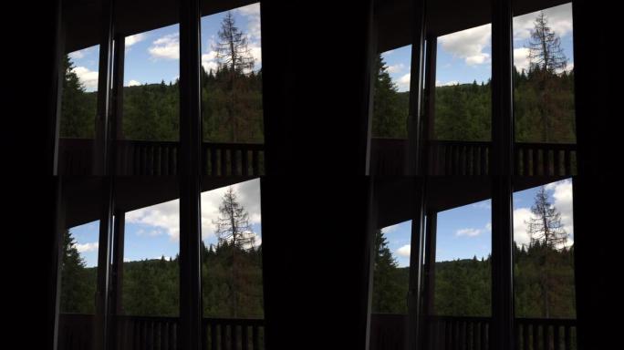 穿过房屋窗户的蓝天的时间流逝。背景上的山脉。