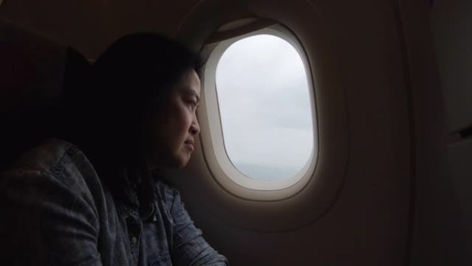 亚洲妇女独自旅行并透过窗户看