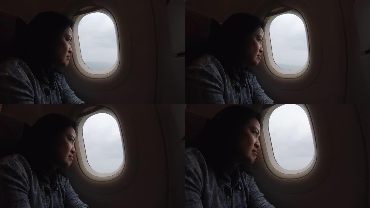 亚洲妇女独自旅行并透过窗户看
