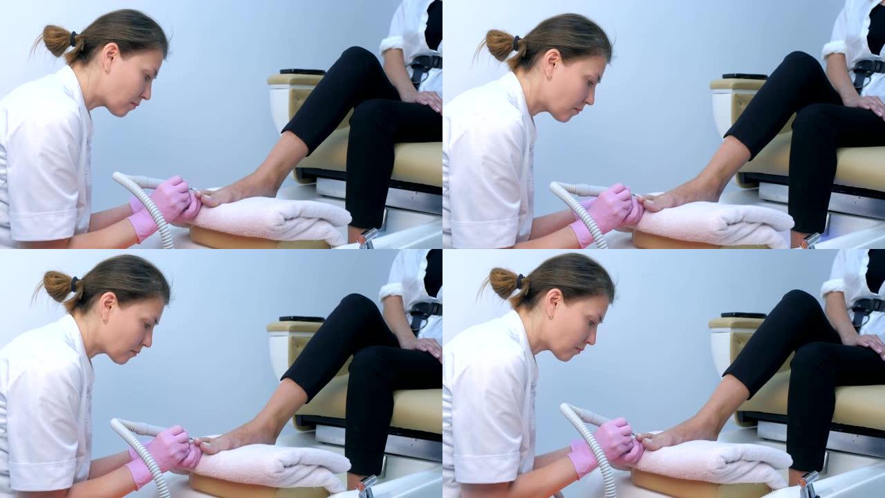 修脚师妇女使用电钻在脚趾上做五金件修脚。