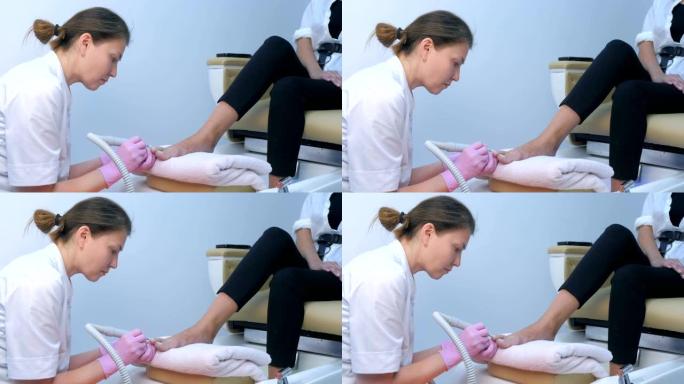 修脚师妇女使用电钻在脚趾上做五金件修脚。
