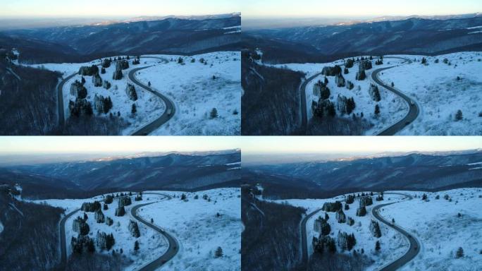 冬季卡车和汽车开槽的蜿蜒山路鸟瞰图