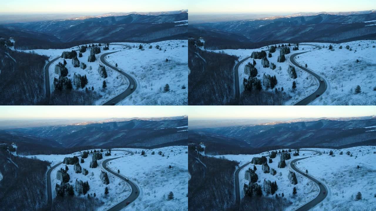 冬季卡车和汽车开槽的蜿蜒山路鸟瞰图