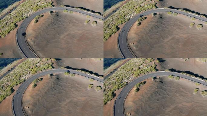 空中射击。往下看。汽车走新的理想平坦的柏油路。新鲜的白色道路标记。以红石沙漠景观为背景。西班牙、加那