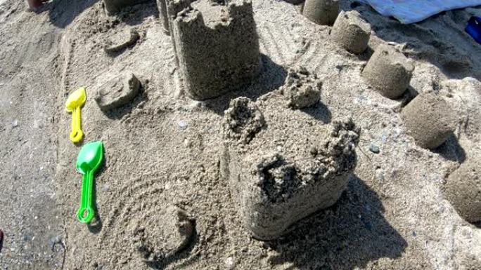 在沙滩蓝海的南岸建造带有塔楼的房屋沙堡