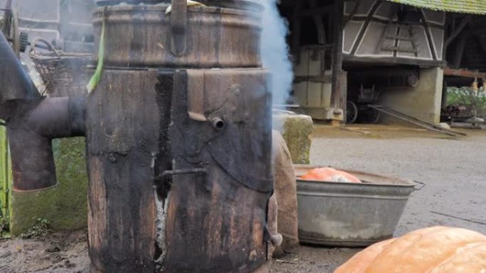 沸腾的金属锅南瓜汤和蔬菜在外面的农场释放大量烟雾