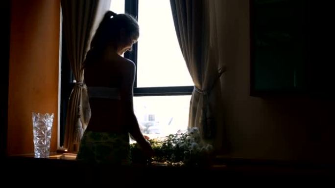 女孩把白花放在窗台上，在家里割根
