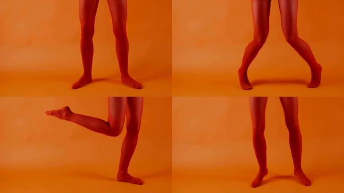 红色长袜在明亮的橙色背景下完美的女人腿上，女模特在工作室跳舞