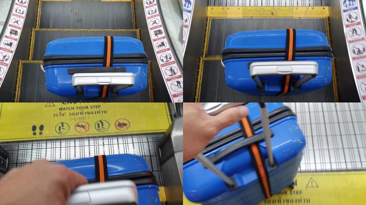 游客带着手提箱站在机场的自动扶梯上