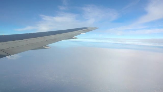 从窗户从飞机侧面看陆地。舷窗中的飞机机翼。