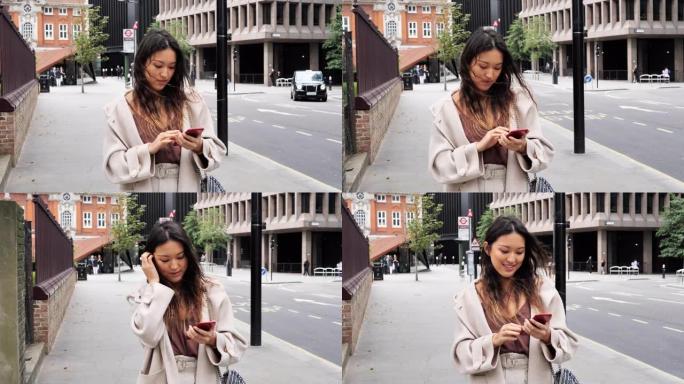 美丽的千禧一代长发中国女人在户外使用智能手机