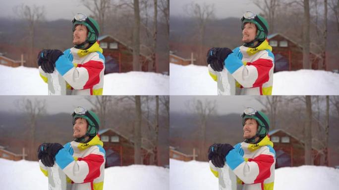 在山区度假胜地，一个戴着头盔和滑雪板的年轻人的特写镜头。寒假概念。慢动作镜头