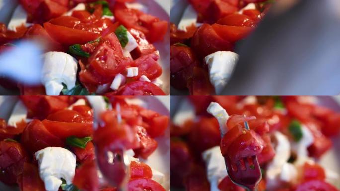 吃卡普雷西切碎的西红柿叉子叉起西红柿