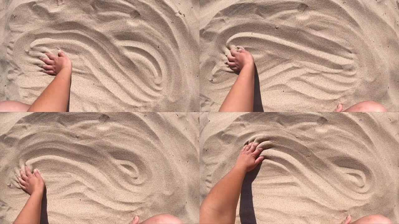手在沙子表面移动，俯视图。男人的手散射