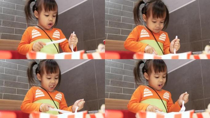 亚洲小女孩喜欢在服务店吃炸鸡。肯德基是世界著名的美国快餐店。健康理念。