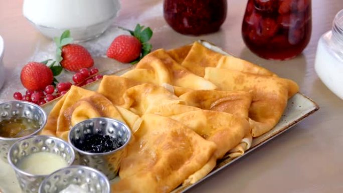 俄罗斯传统煎饼，薄饼配果酱，酸奶油和草莓。特写视图。