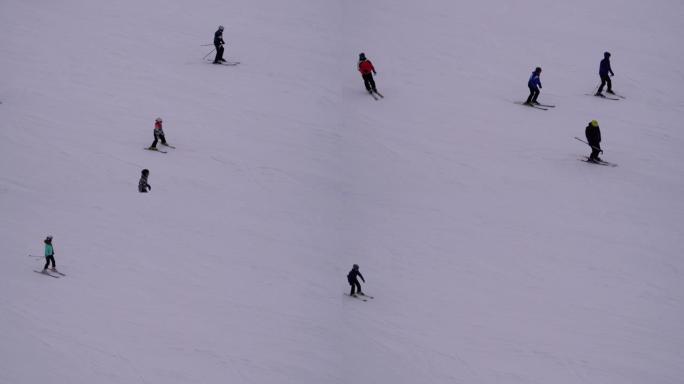 晴天，滑雪者和滑雪者在滑雪胜地的雪坡上骑行