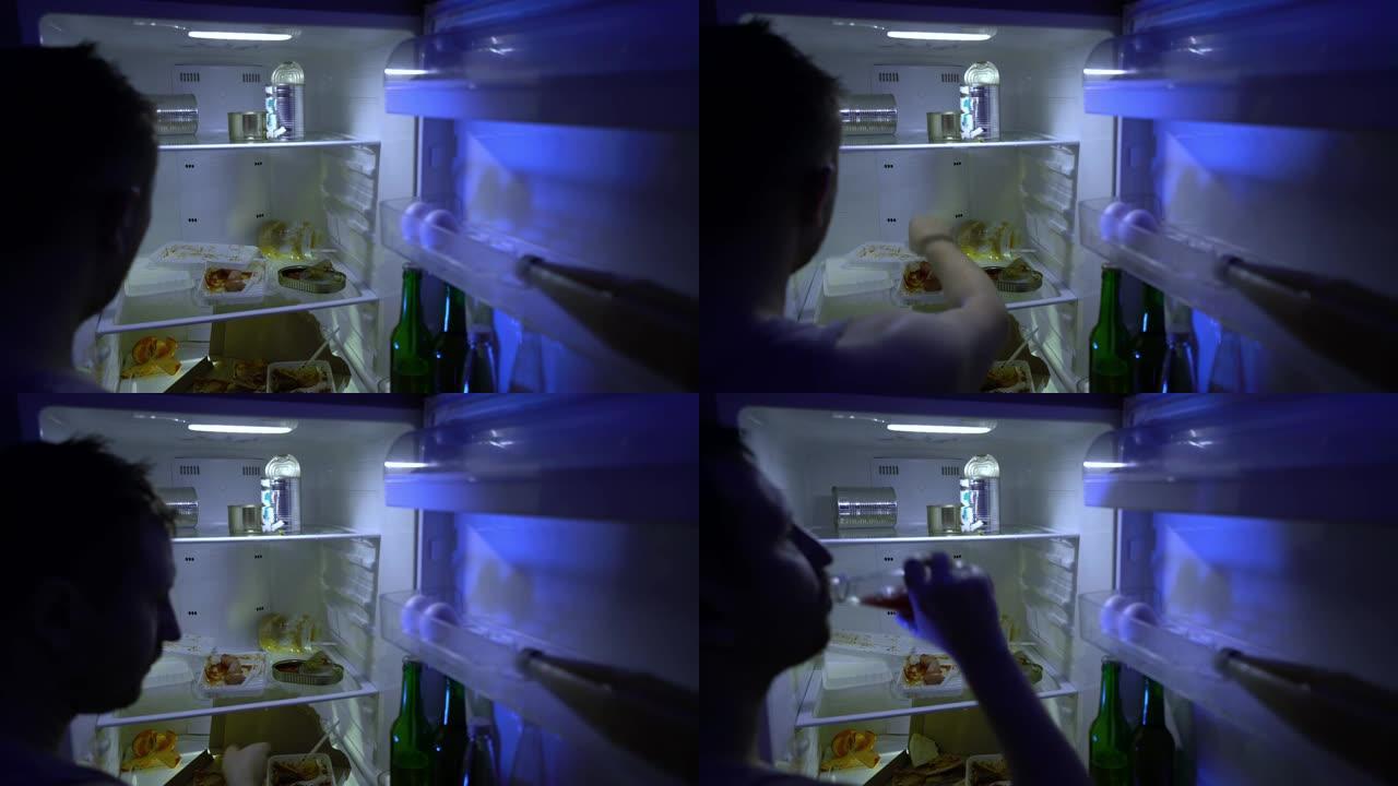 在冰箱里找食物的人。未刮胡子的人在冰箱里挖东西，他拿披萨。