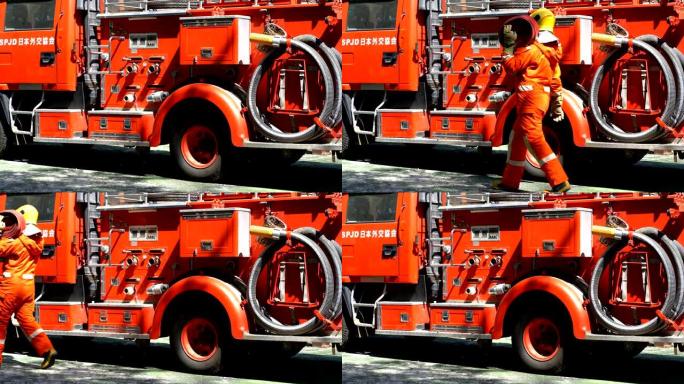 4k消防员在消防车前携带消防水带