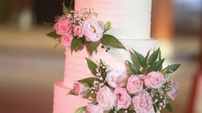美丽的婚礼蛋糕装饰着鲜花和白色和粉红色的色调。