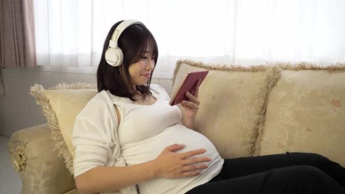 孕妇通过耳机听音乐
