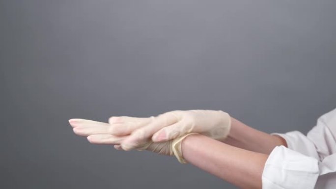戴着一次性手套的女医生正在上面喷洒防腐剂。医学妇女消毒橡胶手套。新型冠状病毒肺炎。