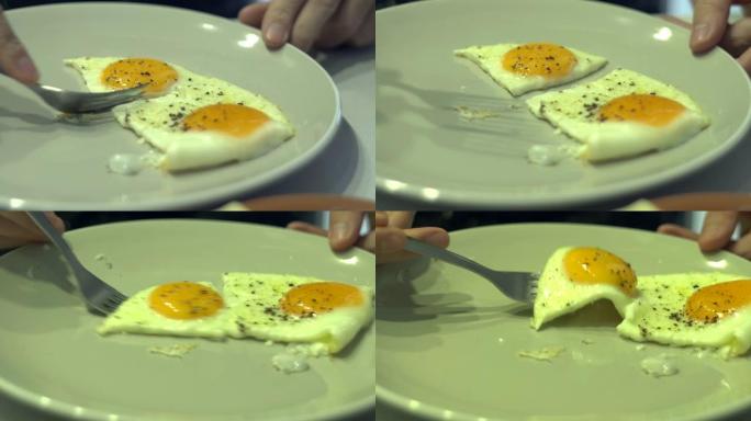 盘子里有叉子的人吃煎鸡蛋