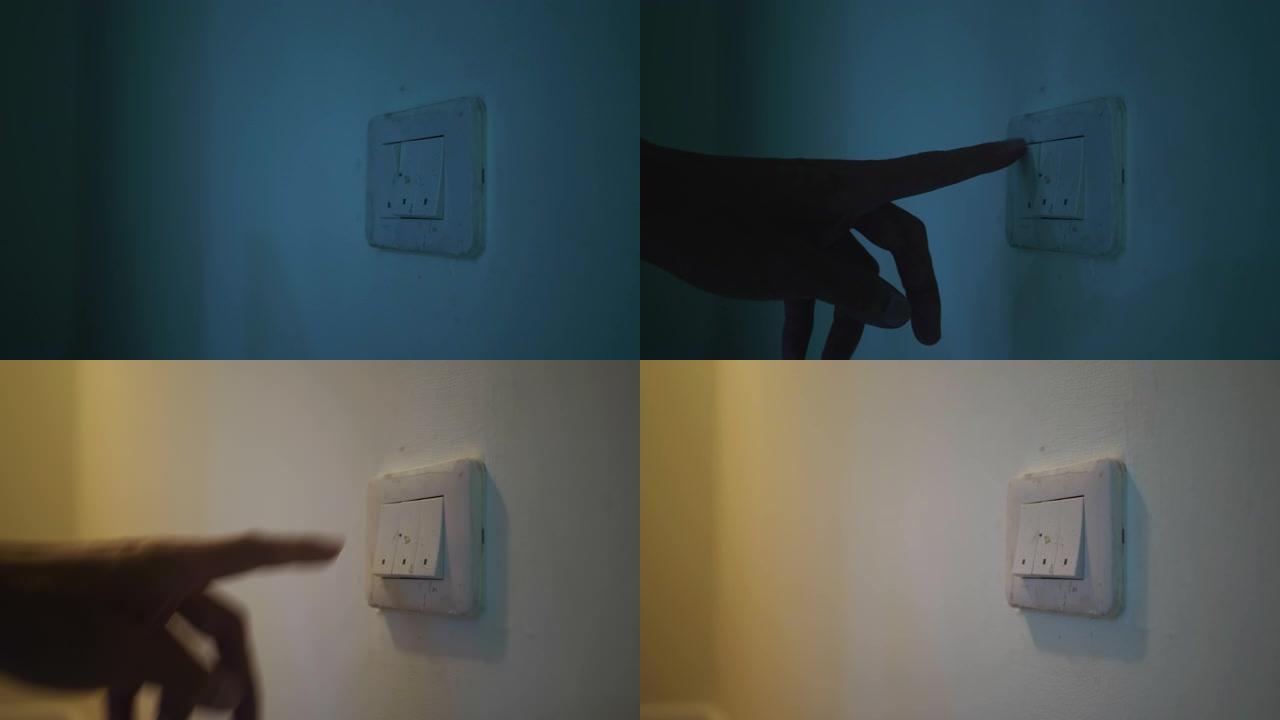 挂在墙上的灯泡在照明开关上用人的手打开。