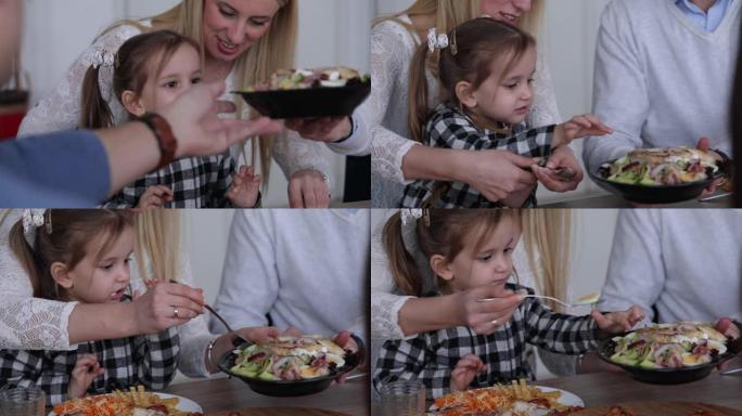 可爱的女孩向母亲展示她想在家庭午餐时吃什么