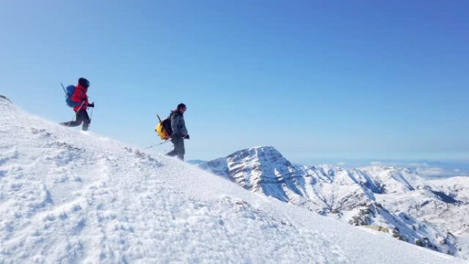 高山登山队冬季在高海拔山峰上连续行走