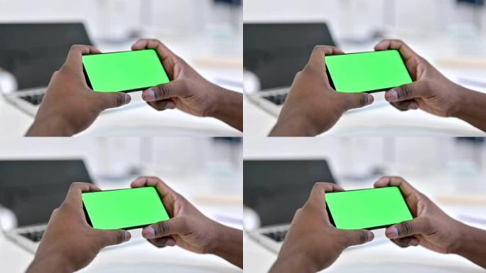 非洲男子在绿色智能手机屏幕上观看视频，色键