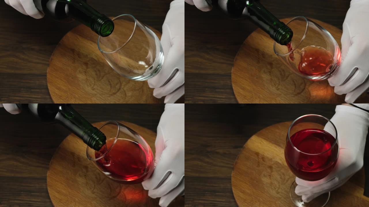 熟练的侍酒师将红酒从瓶子倒入玻璃杯中。特写。